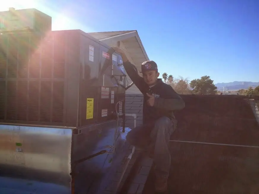 HVAC technician performing AC Tune-Up on a rooftop unit in Brooksville